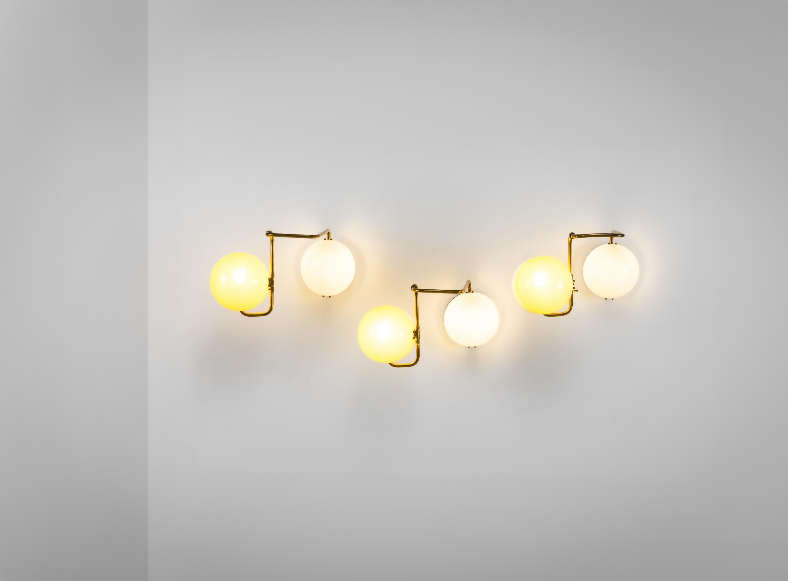 Prodotto in Italia, Tre lampade a parete, struttura in metallo e ottone con diffusori in perspex ...