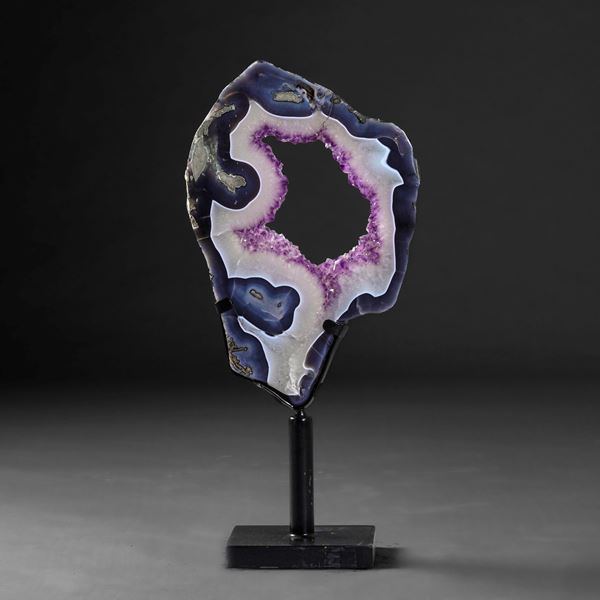 A large, elegant piece of amethyst set on a metal base