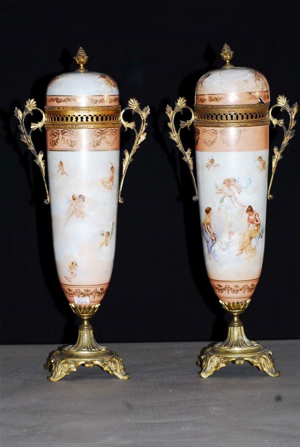 Coppia di vasi con coperchio in porcellana dipinta in policromia con putti su nuvole
