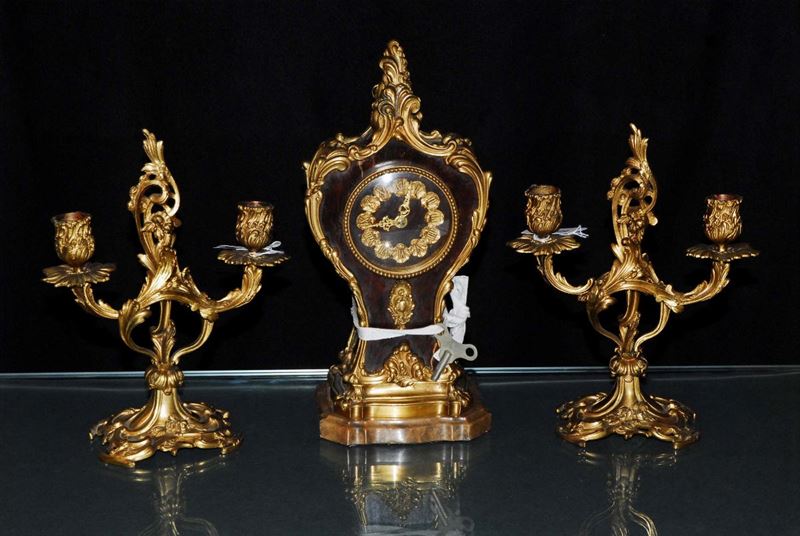 Trittico composto da orologio e due candelieri in legno e bronzo dorato  - Asta Asta OnLine 09-2012 - Cambi Casa d'Aste