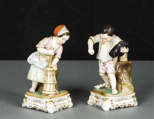 Due statuine in porcellana decorata in policromia raffiguranti bambini