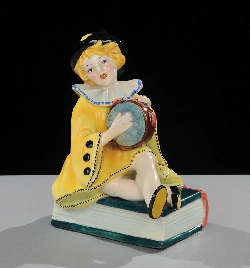Statuina in porcellana raffigurante pagliaccetto seduto su libro, XX secolo  - Asta Asta OnLine 05-2012 - Cambi Casa d'Aste