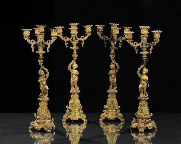 Quattro candelieri in bronzo dorato e sbalzato a quattro luci, inizio XIX secolo