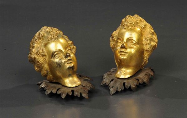 Due testine di putto in bronzo dorato, XIX secolo