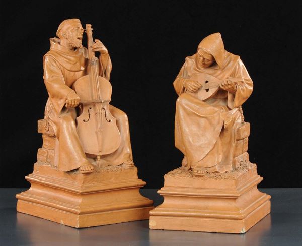 Due sculture in terracotta raffiguranti frati che suonano