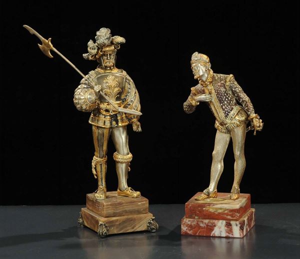 Coppia di statuine raffiguranti guerrieri placcate in oro e argento