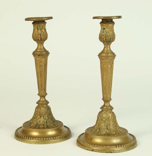 Coppia di candelieri in metallo dorato, XX secolo