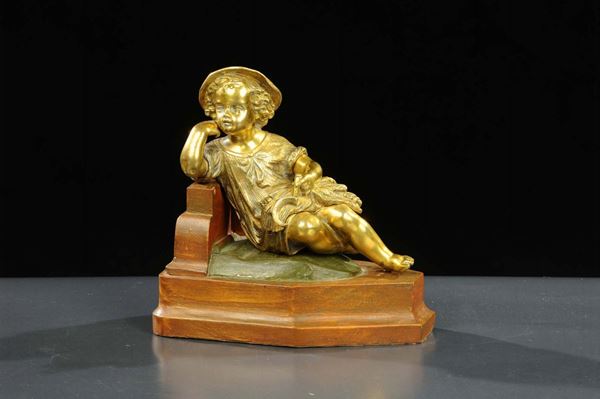 Scultura in bronzo dorato raffigurante bambino con falce